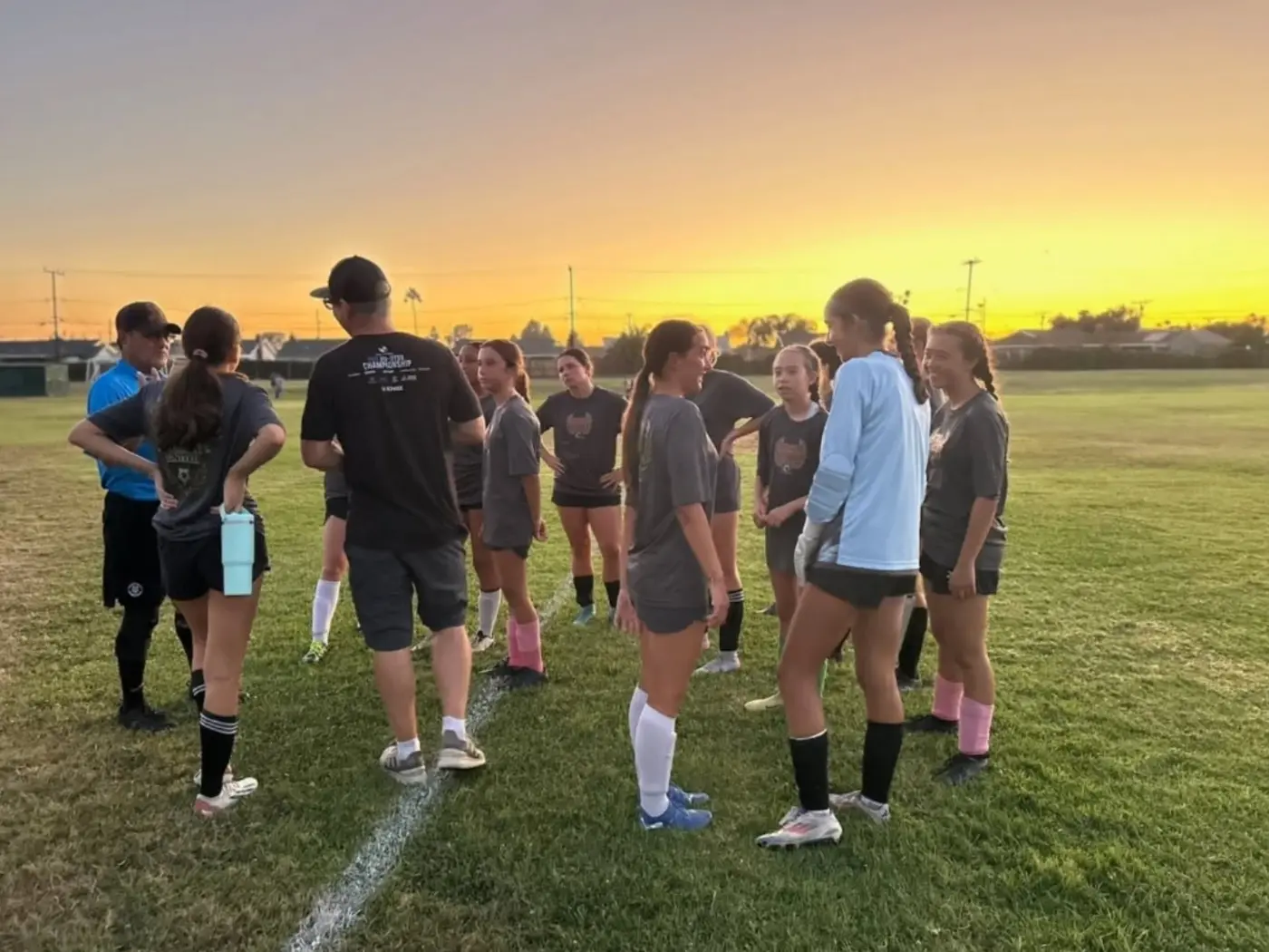 Players circled up for an end-of-session team talk as the sun sets